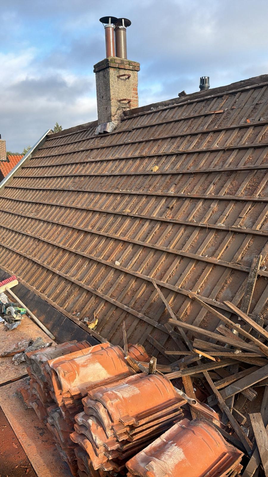 Gestript dakvlak met oude dakpannen op pallets