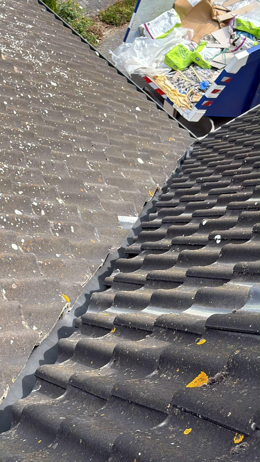 Bemoste betonpannen naast een bitumen dakvlak